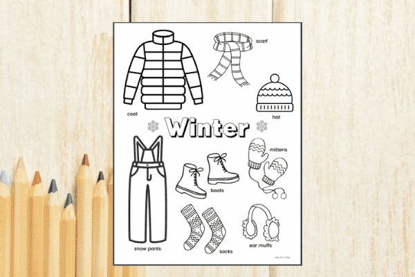 Winter Clothes Worksheet  - preschool winter coloring page shown on a light wood background with colored pencils.