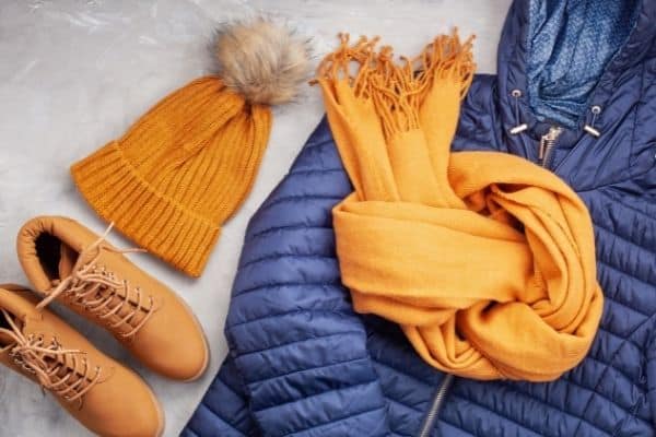 Winter Clothes game - boots, mustard yellow hat and scarf with a blue coat shown