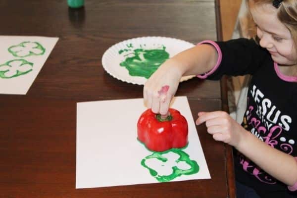 Shamrock stamping with a pepper - a child shown dipping a pepper into paint and stamping it onto paper