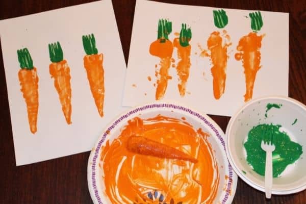 completed carrot stamping crafts shown with paint dishes