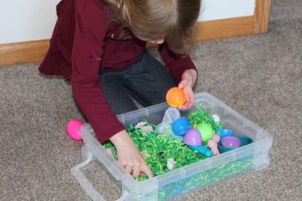 Child color sorting in an Easter sensory bin