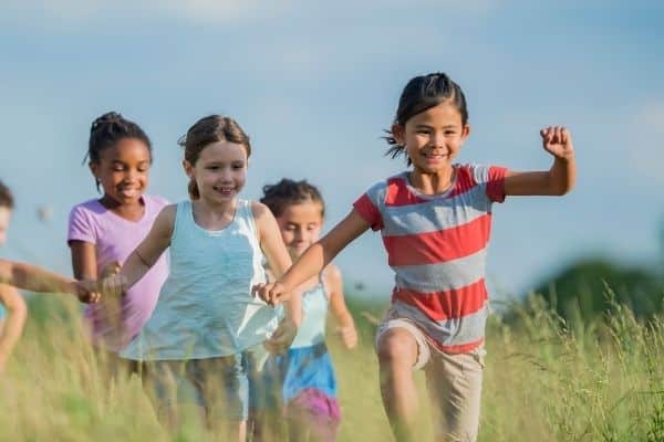 A group of kids playing follow the leader outside