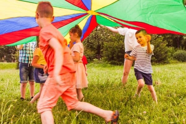 Parachute activity - kids running underneath a giant parachute