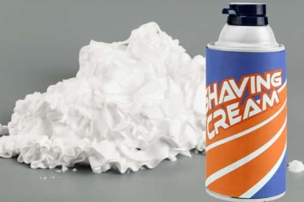 shaving cream bottle shown with a pile of shaving cream