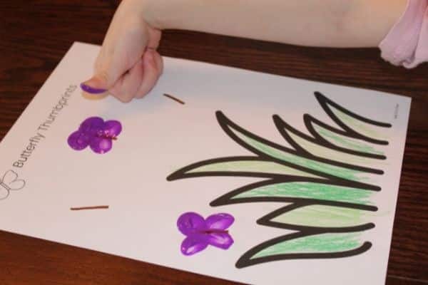 Child thumbprinting a butterfly