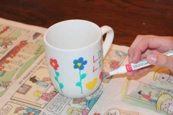 child coloring flowers on a personalized coffee mug