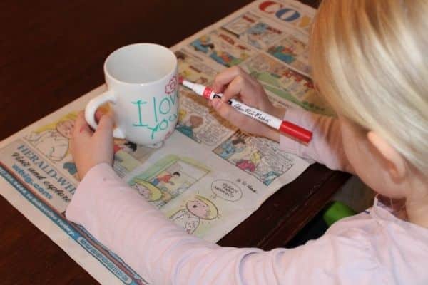 child painting a diy coffee mug