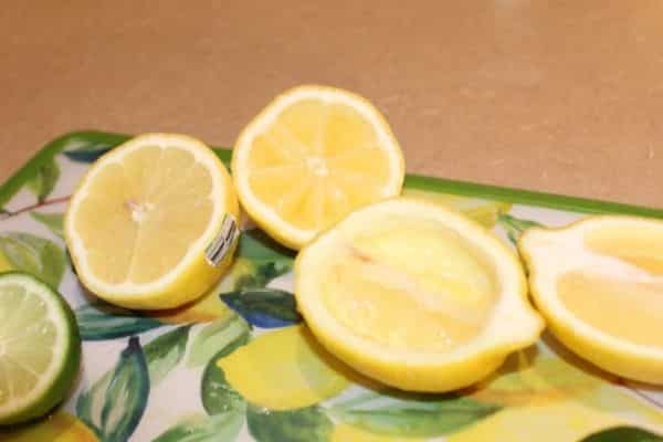 2 lemons cut on a cutting board, one sliced lengthwise, and the other sliced to show the segments