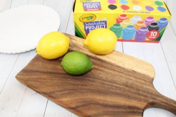 lemons and lime on a wooden board pictured with paper plates and kids washable paint