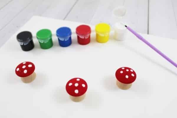 Wooden mushrooms painted red with white dots on top for forest sensory play activity