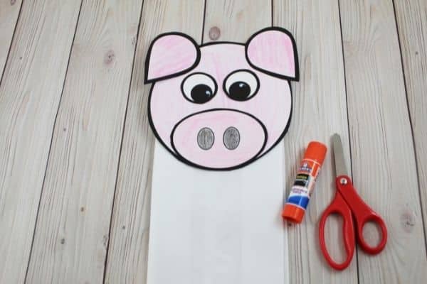 paper bag pig puppet assembled with glue stick and scissors