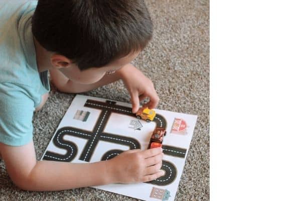 Printable roads - child playing with cars on printed roadways