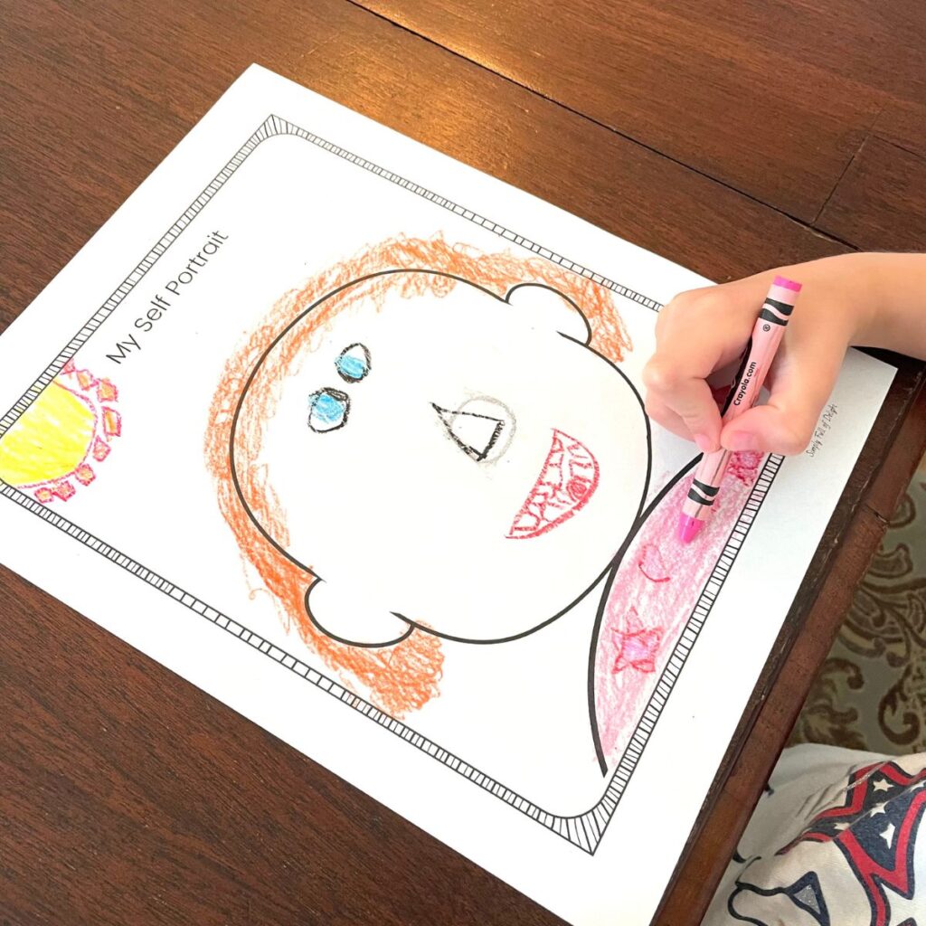 Child coloring a self portrait all about me printable with red hair and teeth!