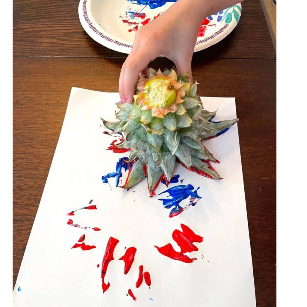 child stamping with a Pineapple making a Fireworks Craft for Preschool - a fun  Independence Day craft for kids!