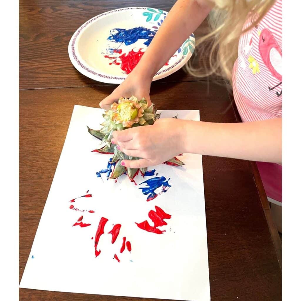 Child doing Pineapple Stamping Fireworks Craft for Preschool - a fun craft for 4th of July