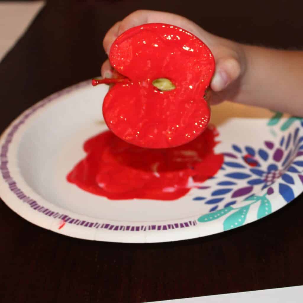 apple dipped in red paint for painting with apples