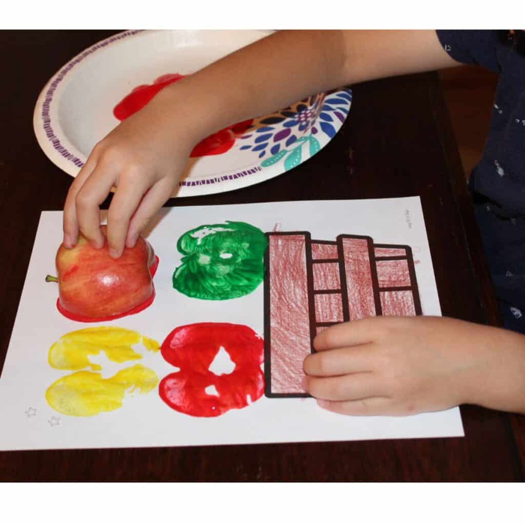 child stamping apples onto an apple basket craft printable