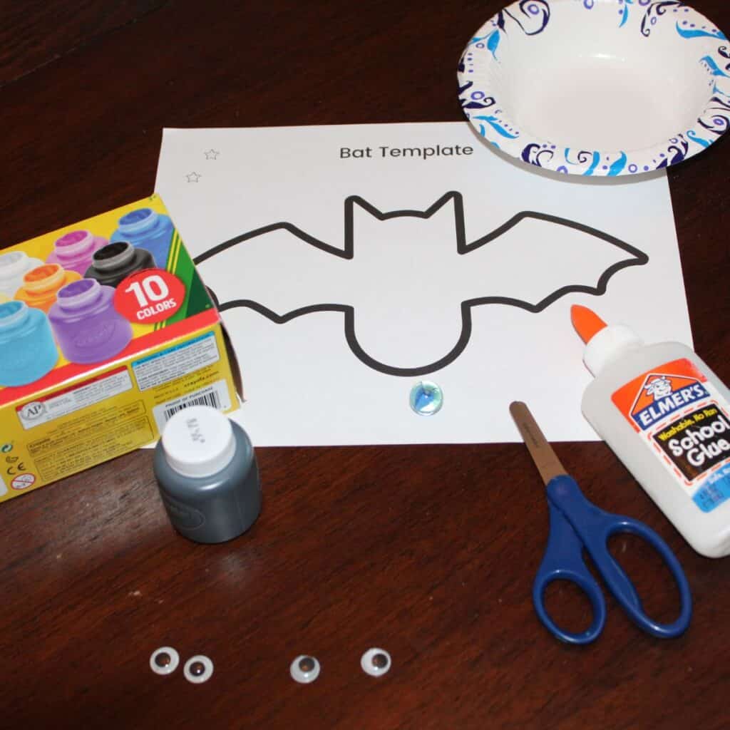 Supplies for preschool bat craft - free printable bat template, washable kid paint, glue, scissors, marble, bowl