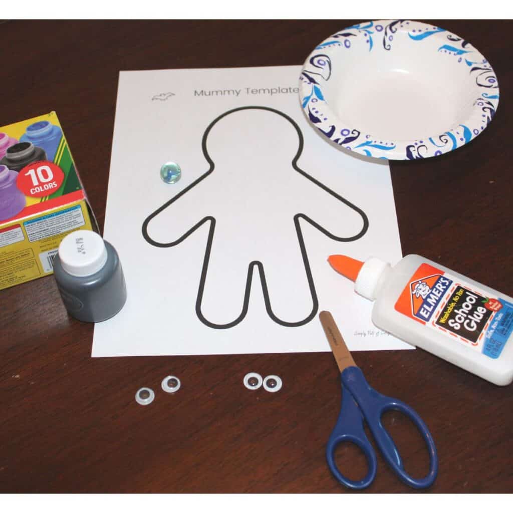 Supplies for Easy paper mummy craft for preschoolers - washable paint, marble, googly eyes, glue, scissors, bowl, and mummy template PDF