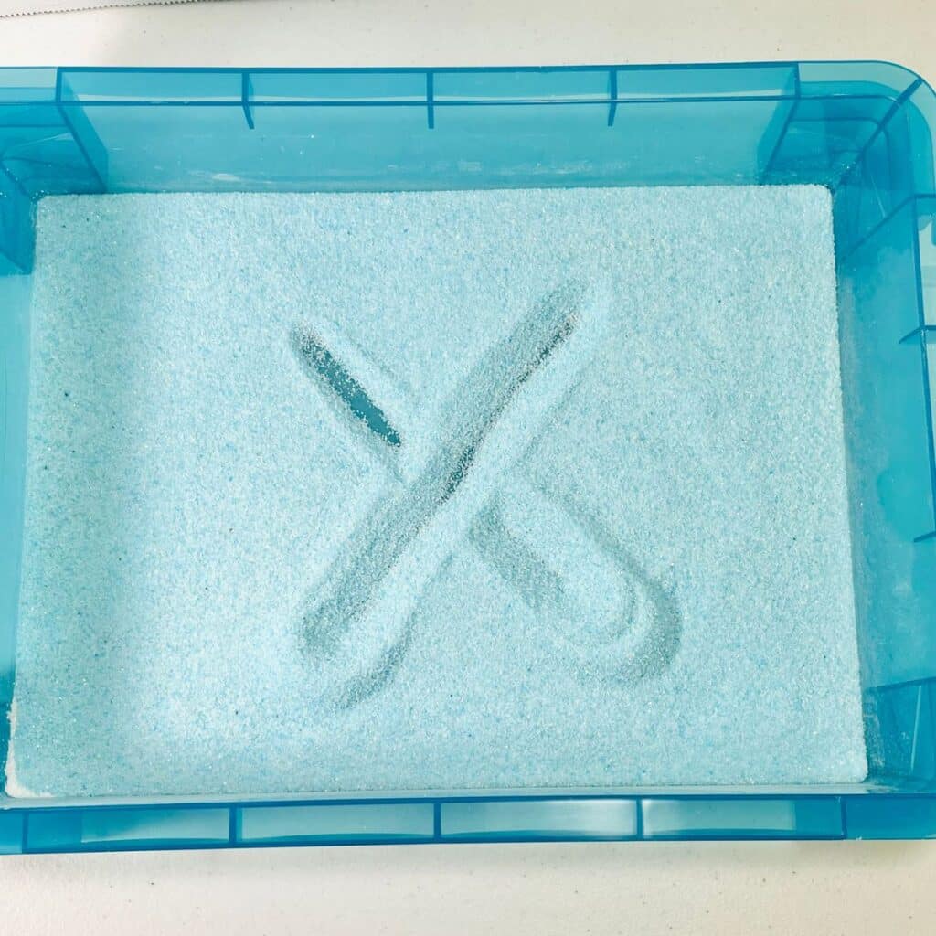 Letter tracing box - colored sand in a letter writing tray for preschoolers and kindergarteners to practice letter formation