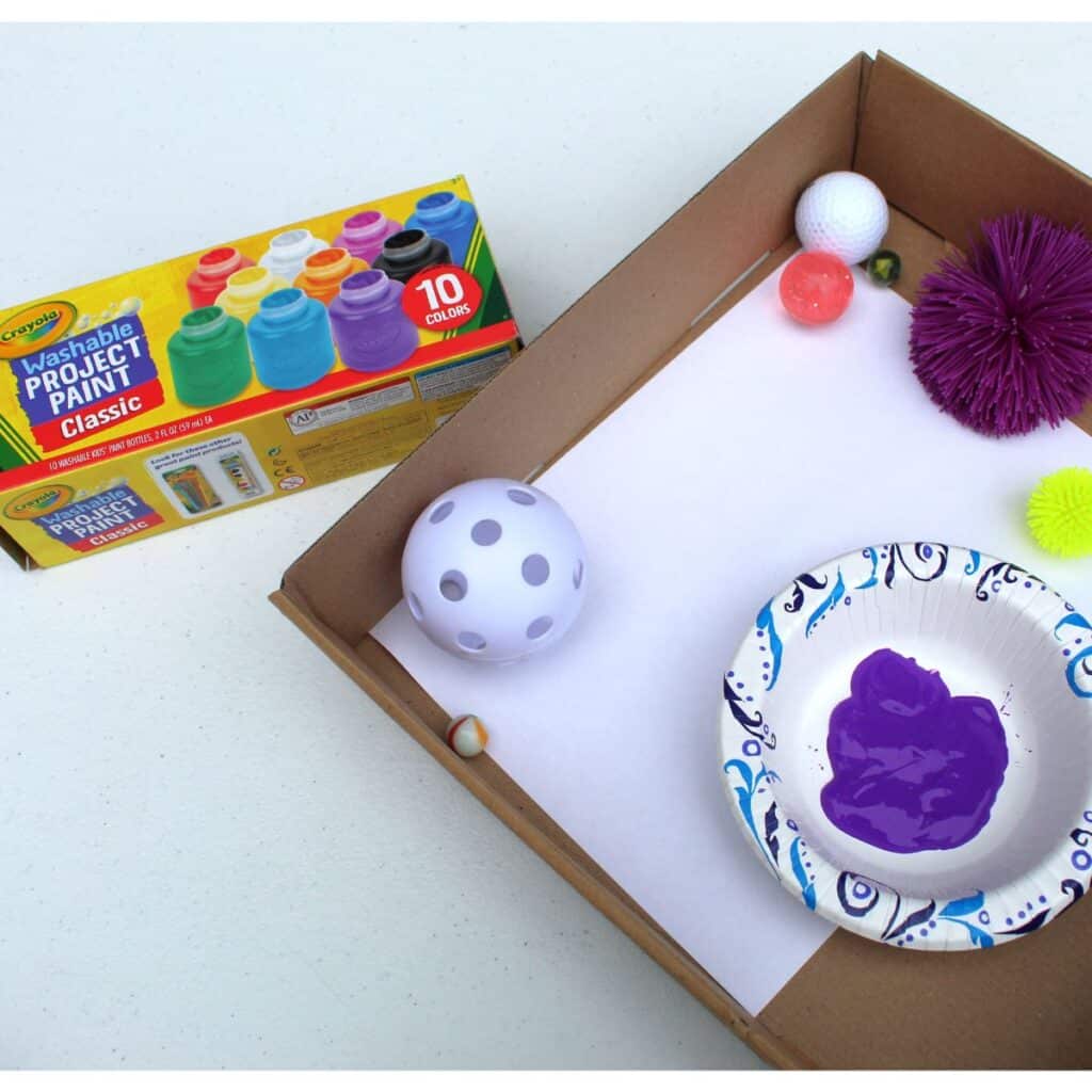 Painting with balls - a fun preschool learning activity  - washable paint shown with a box of various balls.
