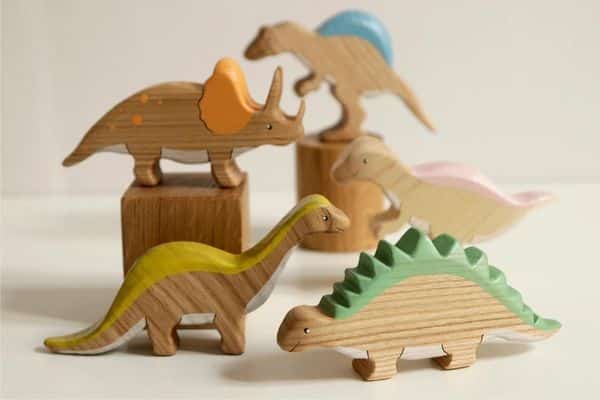 wooden dinosaurs set from Woodwork Love Shop - brontosaurus, stegosaurus, and 3 more dinos shown in background