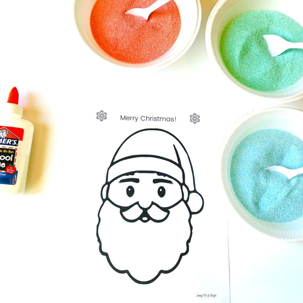 easy preschool Santa craft with free Santa face printable - shown: free printable Santa face, colored sand, and glue