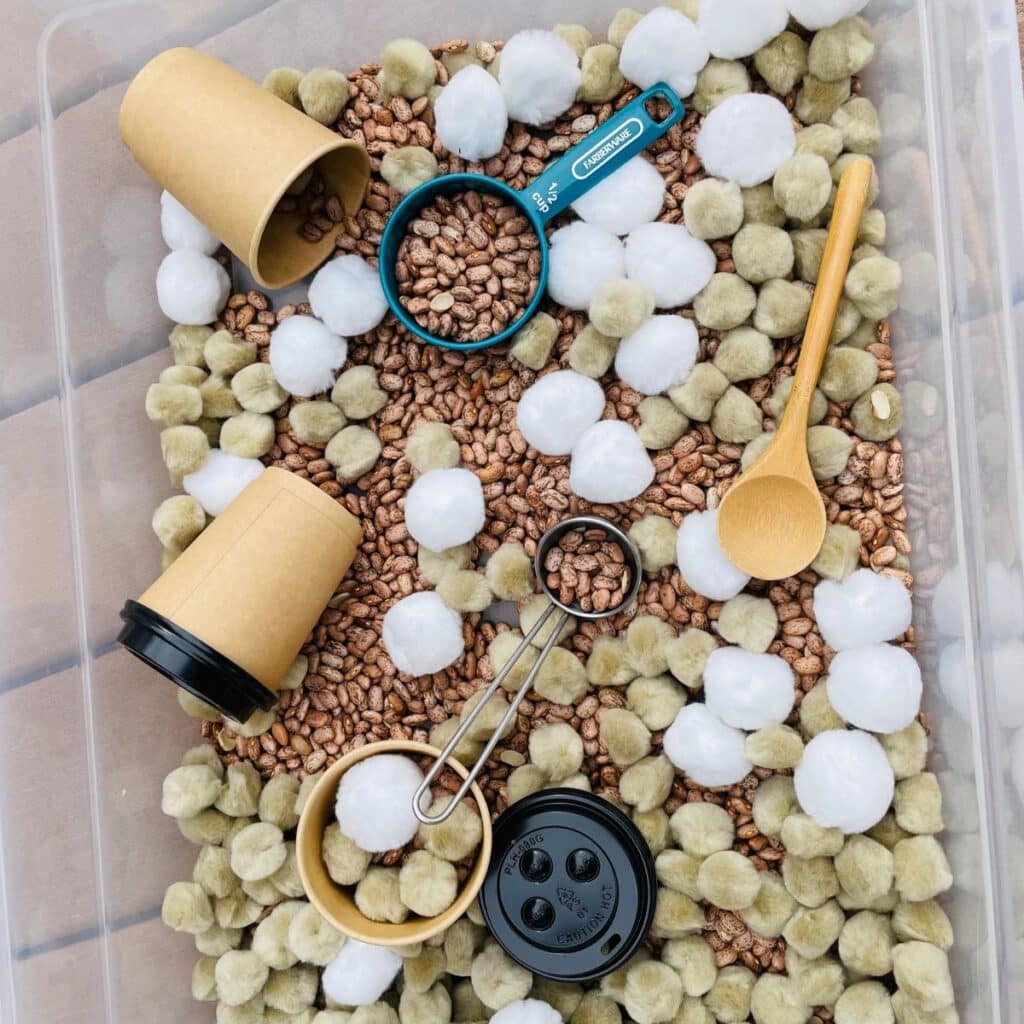 Hot Cocoa Sensory Bin - a fun winter sensory bin for preschool!  This hot chocolate sensory bin contains beans, pom poms, scoops and more!