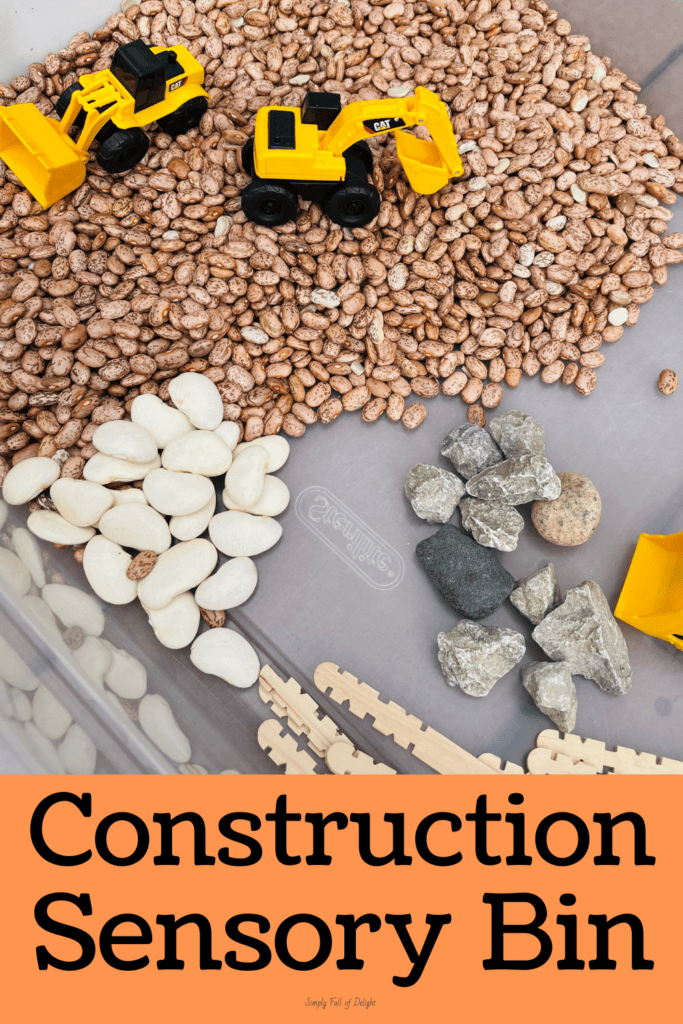 Construction sensory bin - a construction site sensory play idea for preschool - bin contains beans, rocks, toy construction vehicles, sticks, wood chips and more!