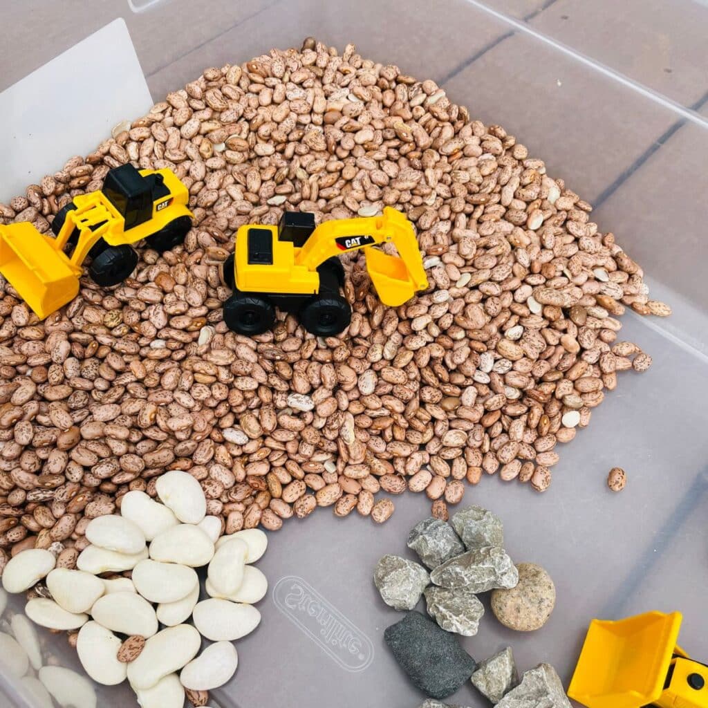 construction sensory play idea - construction vehicles, beans, lima beans, rocks, and more!