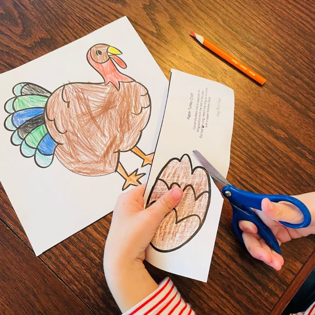 child cutting out the simple turkey paper craft