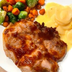 gluten free pork chop recipe shown with potatoes and veggie saute