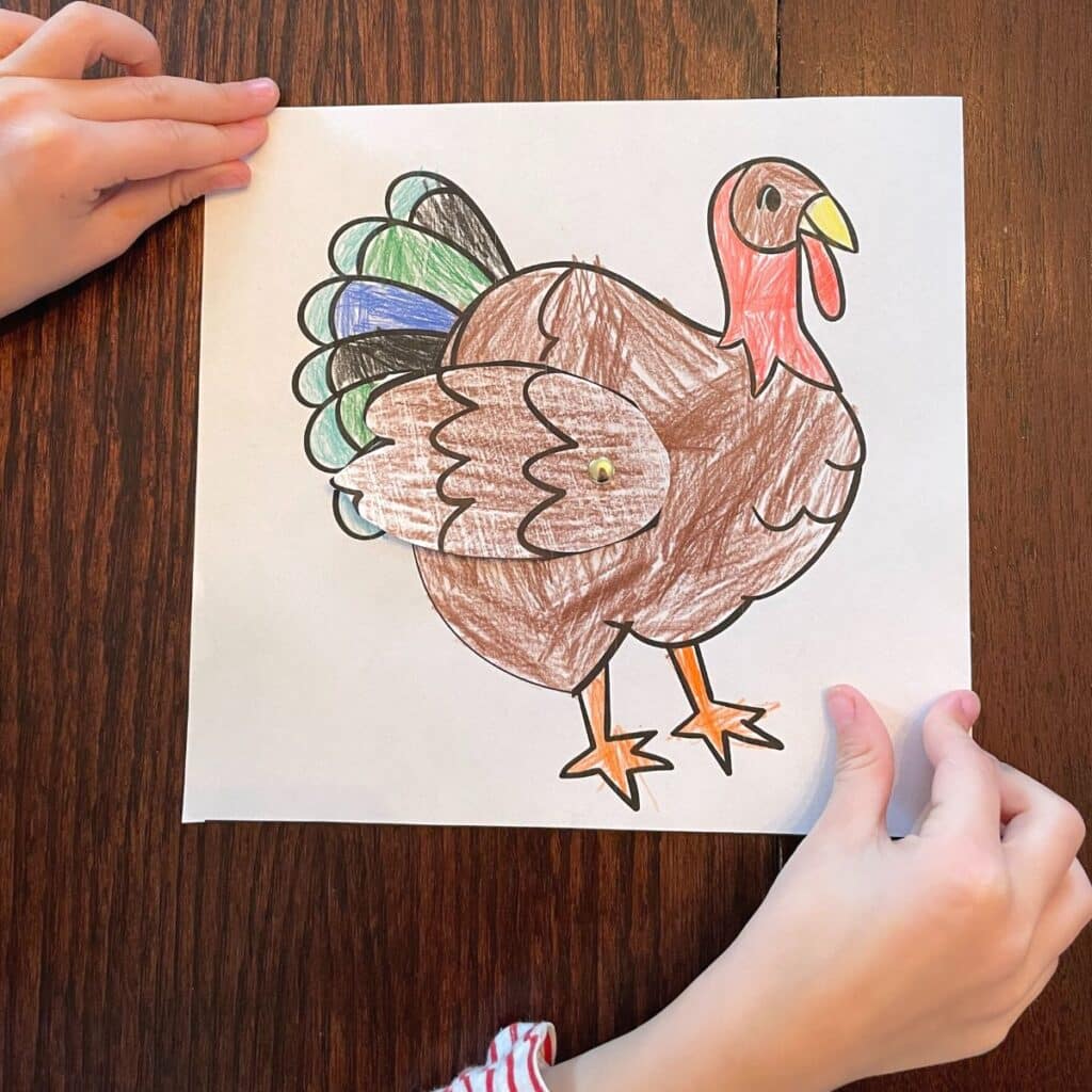 child holding paper turkey craft