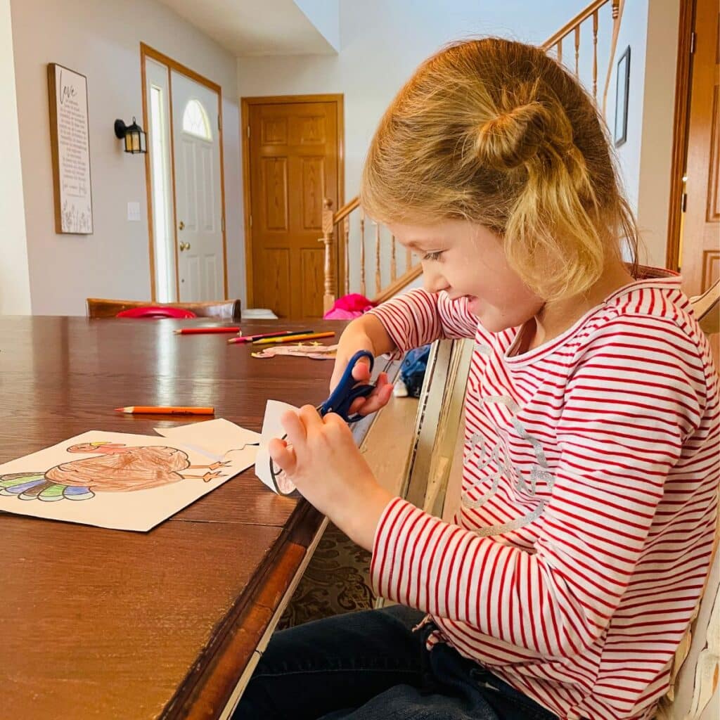 child cutting out a turkey paper craft