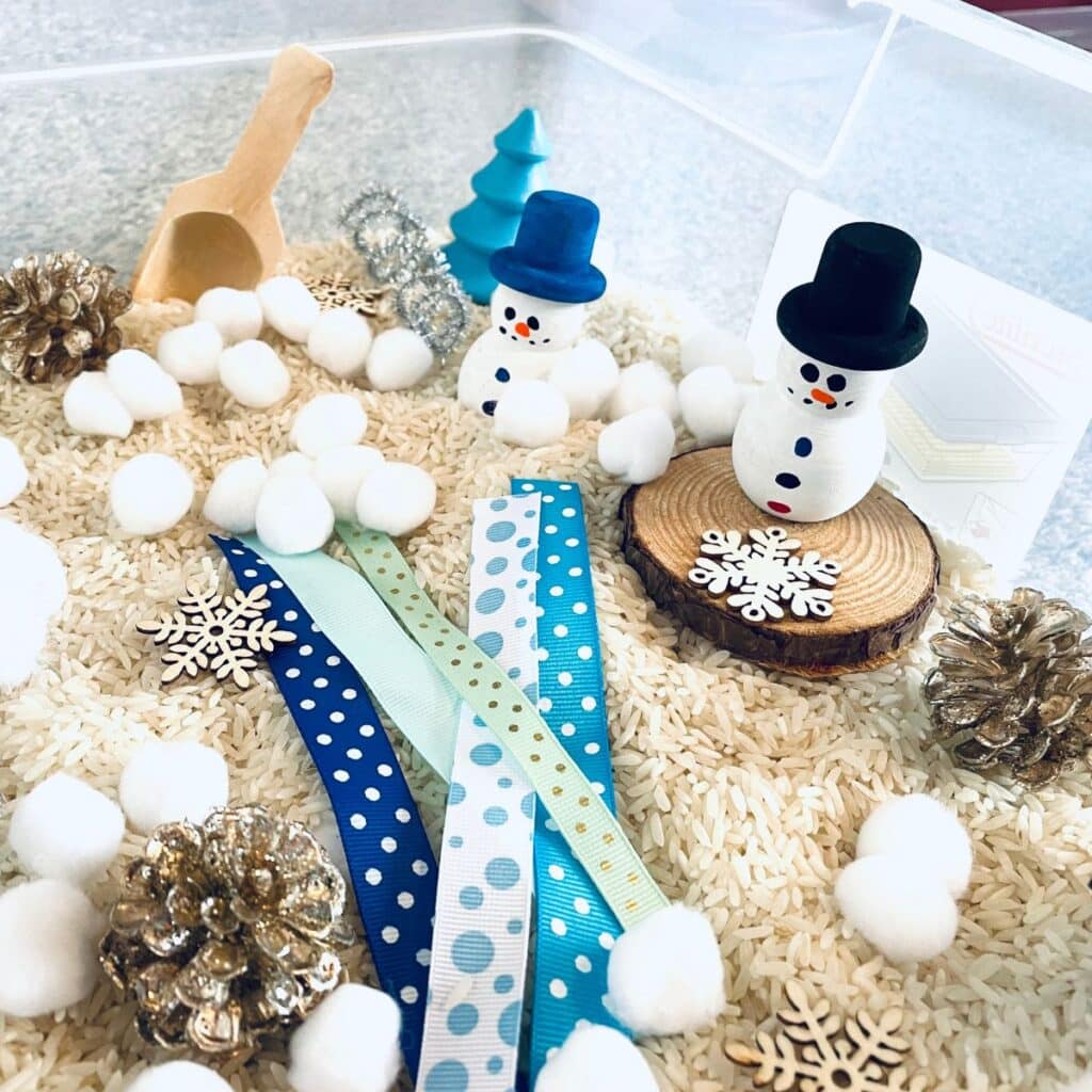 snowman sensory bin - pom poms, wooden snowmen, ribbon, and more!