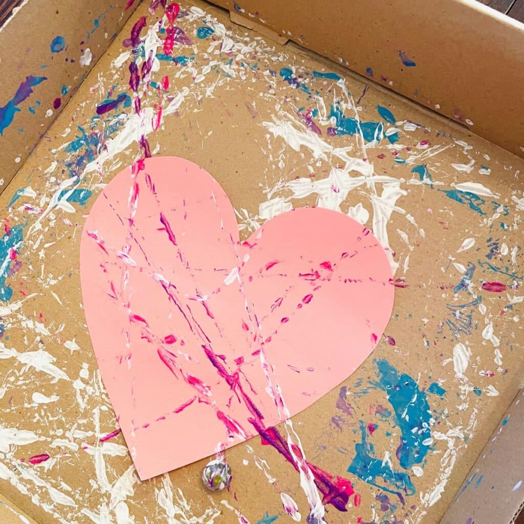 Valentine's Day heart inside a box with paint trails made by marble