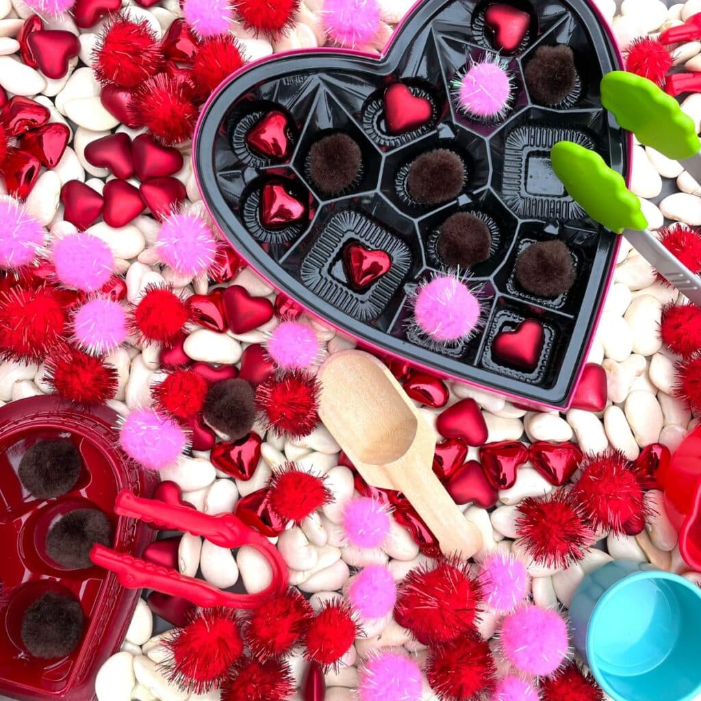 Valentine sensory bin - a chocolate box with pom poms sensory bin for Valentine's day sensory play