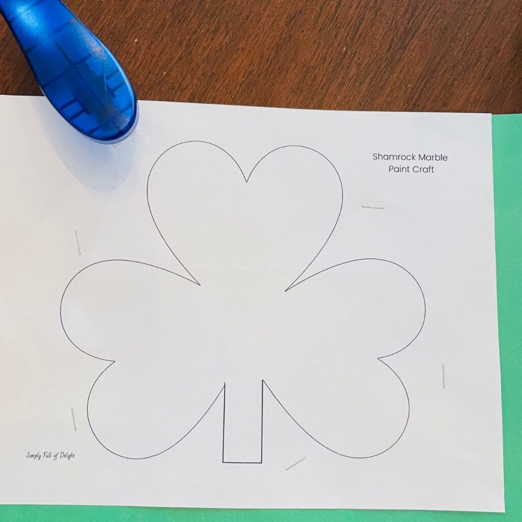 Shamrock template stapled to stack of colored paper