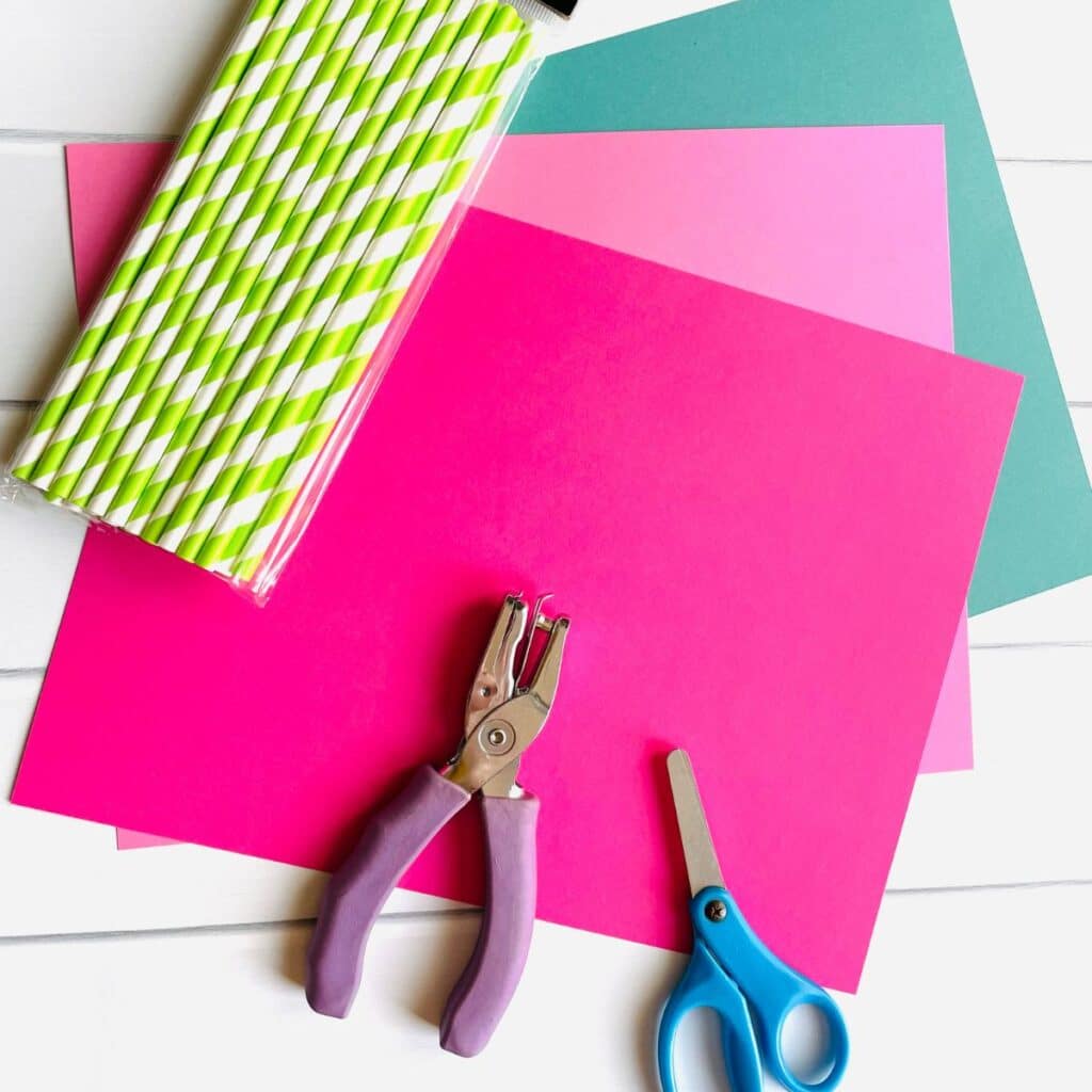 flower craft preschool supplies - pink and green cardstock, green paper straws, hole punch and scissors