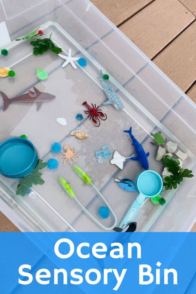 Ocean sensory bin - sensory tub filled with plastic sea animals, measuring cups, tongs, rocks, pompoms and gems