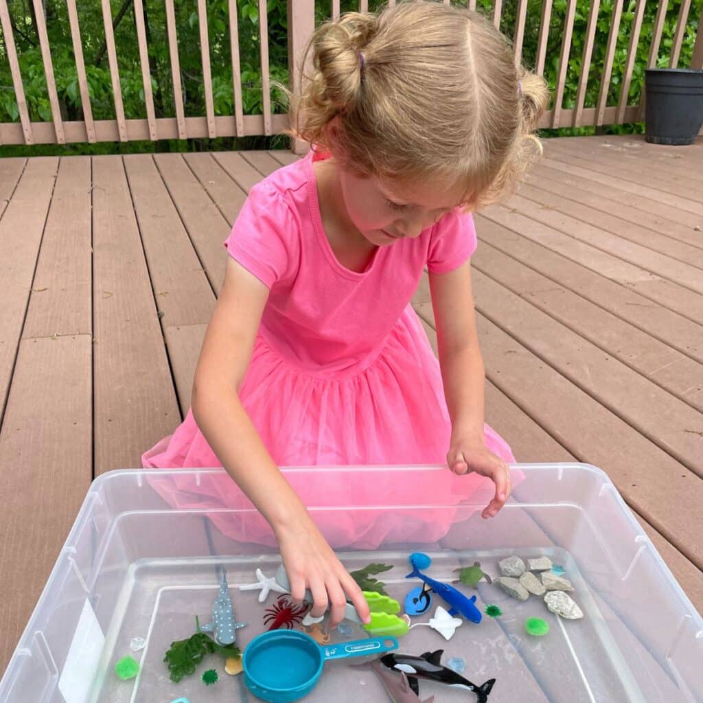 child playing with ocean sensory bin