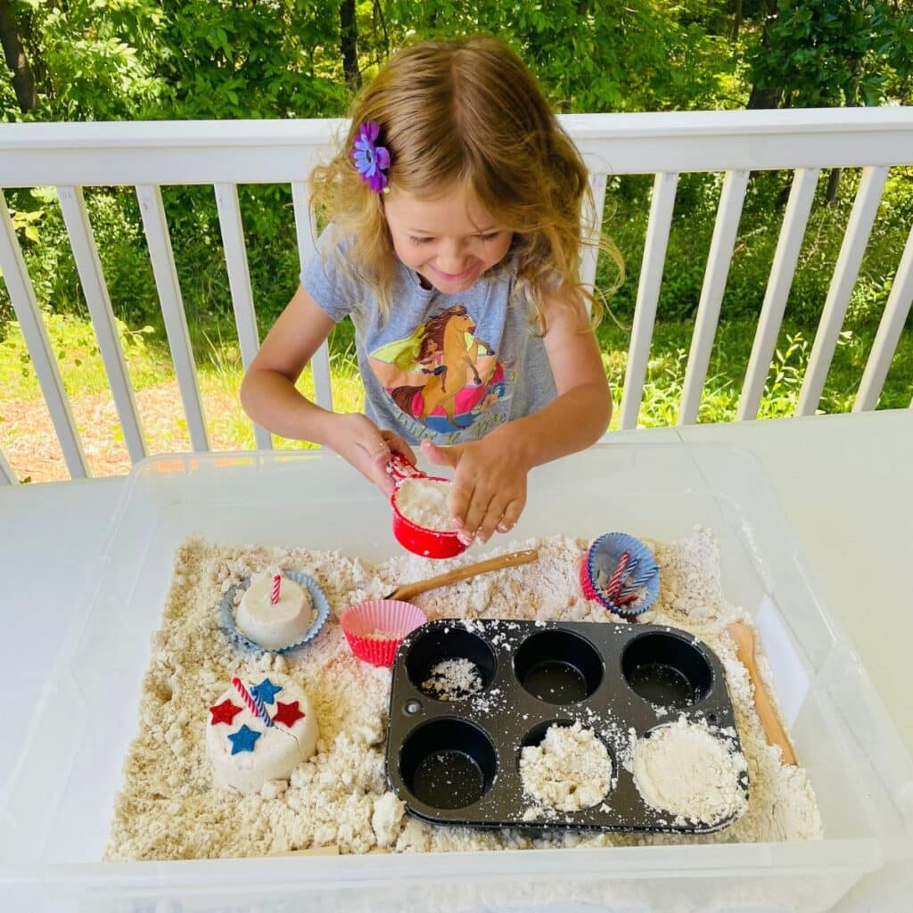 child playing in patriotic cupcake sensory bin