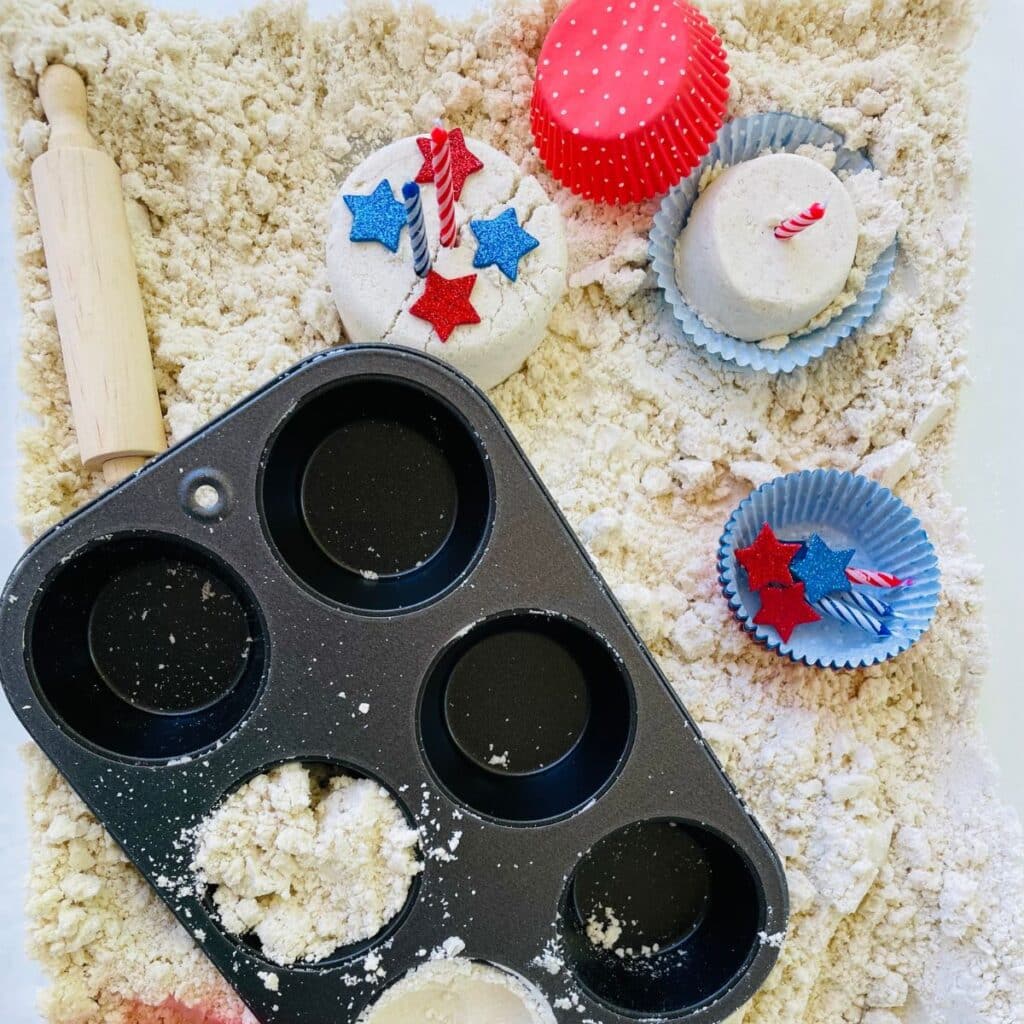 4th of July patriotic sensory bin - moon sand with muffin pan and cupcake making supplies.