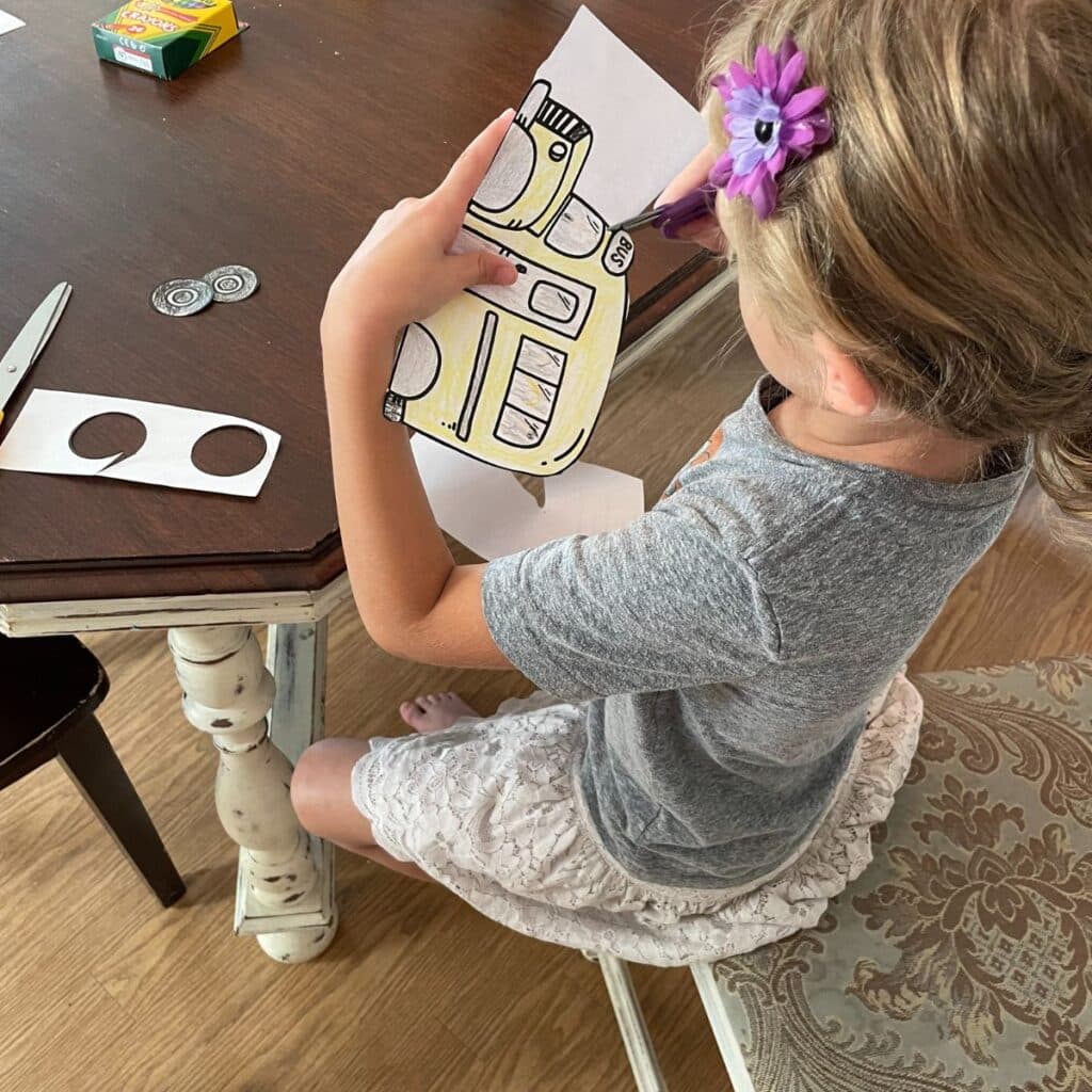 child cutting out bus craft