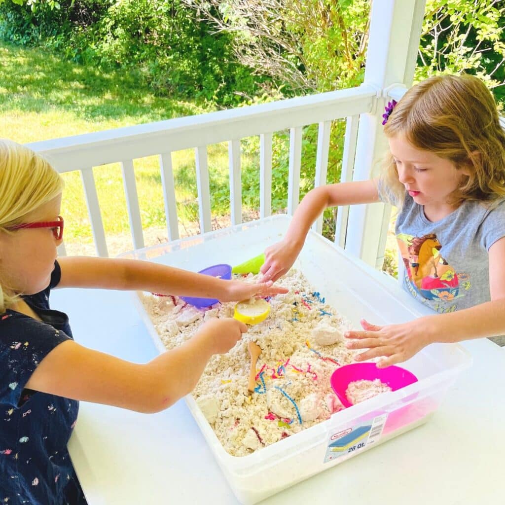 2 kids playing in an ice cream sensory bin