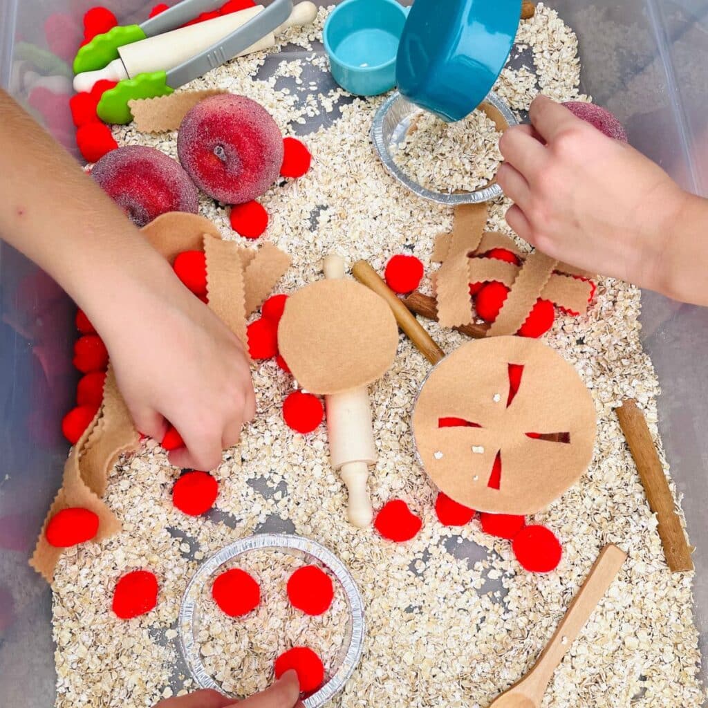 kids filling the pie pans with oats and red pom poms