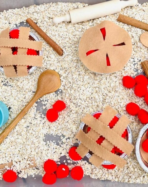 apple pie sensory bin with felt pie crusts, oats, pom poms and scooping tools