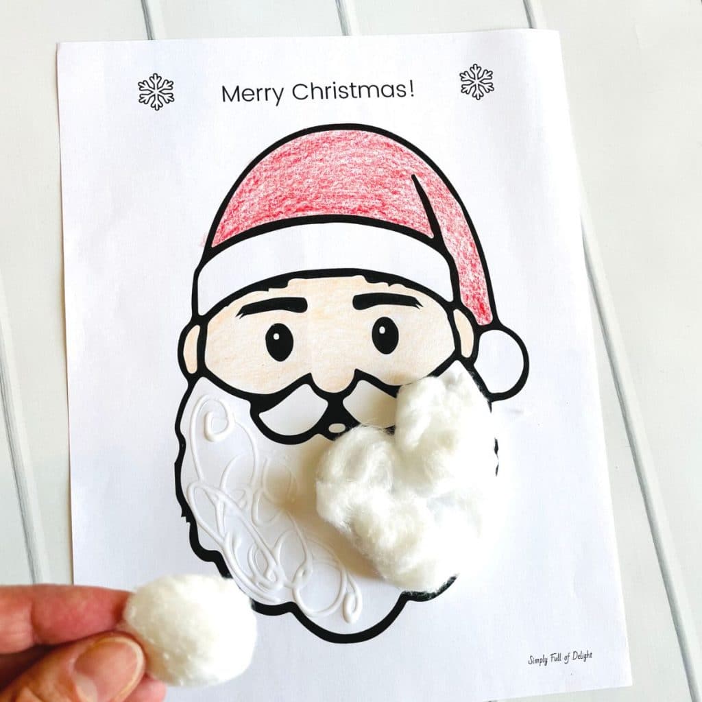 adding cotton balls to the santa beard