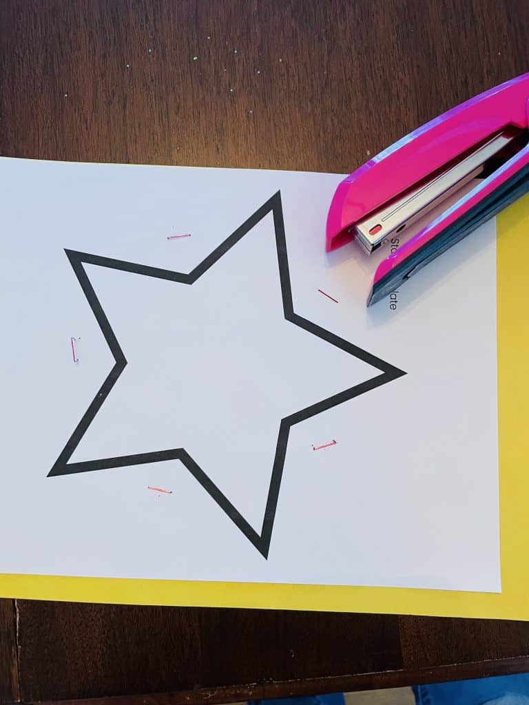 star template stapled to stack of construction paper