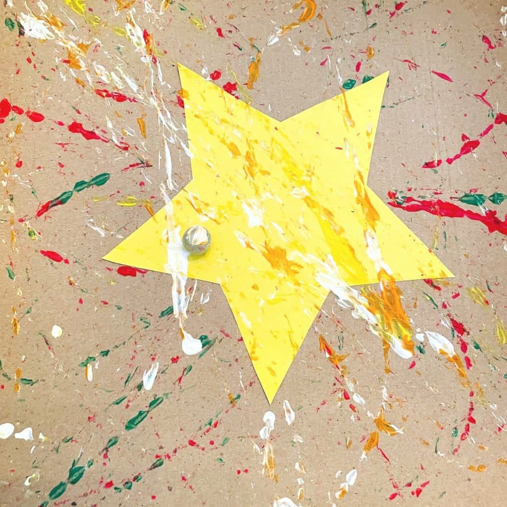 marble painting a yellow star paper craft with white and orange paint